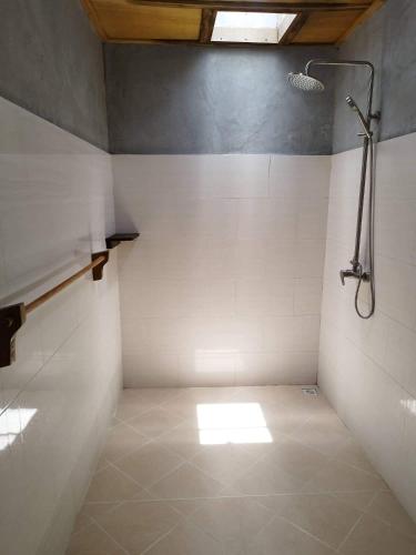bagno con doccia e pavimento piastrellato di Reethi Villa Vaavu Thinadhoo a Thinadhoo