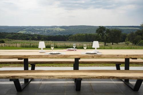 a wooden table with wine glasses on top of it at Gîte XXV House - 8 personnes in Héron
