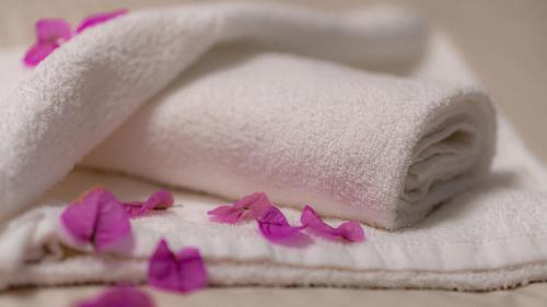 a white towel with purple flowers on top of it at 1st floorC in Pula