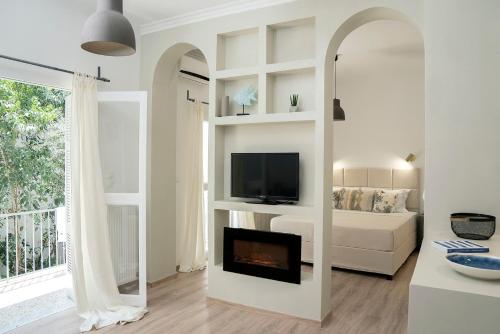 een woonkamer met een open haard en een televisie bij Romantic apartment with hot tub next to Acropolis in Athene