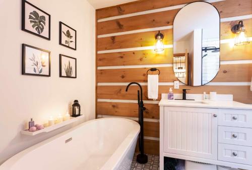 ein Badezimmer mit Badewanne, Waschbecken und Spiegel in der Unterkunft Hjort cottage - 4 Bedrooms 9 people 2 bathrooms in La Macaza