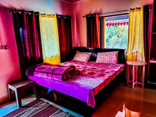 a bedroom with a bed with colorful curtains and a window at Namaste Homestay in Almora