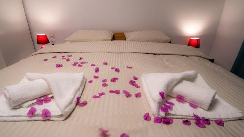 a bed with pink flowers on the sheets at 1st floorC in Pula