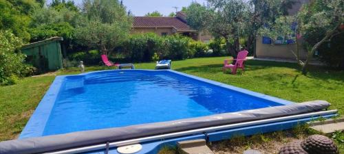 einen Pool in einem Garten mit zwei Stühlen in der Unterkunft VILLA KAPETANAKIS in Redessan