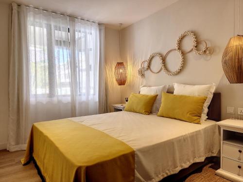 a bedroom with a large bed with yellow pillows at Sunkissed - Brand New Beach apartment located 50m from beach in Flic-en-Flac