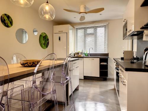 a kitchen with a counter with chairs and a ceiling at Sunkissed - Brand New Beach apartment located 50m from beach in Flic-en-Flac