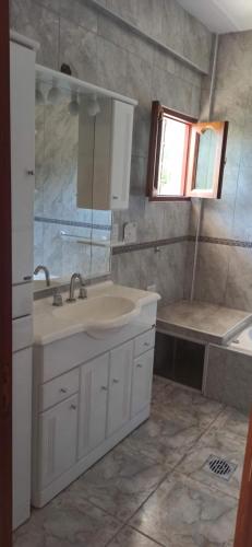 ein Badezimmer mit einem weißen Waschbecken und einer Badewanne in der Unterkunft La Viajera in San Lorenzo