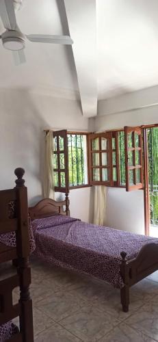 a bedroom with two beds in a room with windows at La Viajera in San Lorenzo