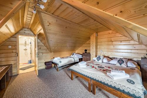 a bedroom with two beds in a log cabin at Apartamenty u Bacy in Jurgów
