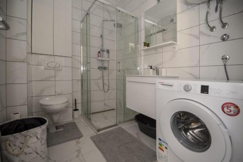 a bathroom with a washing machine and a toilet at APARTMAN DERETIC in Trebinje