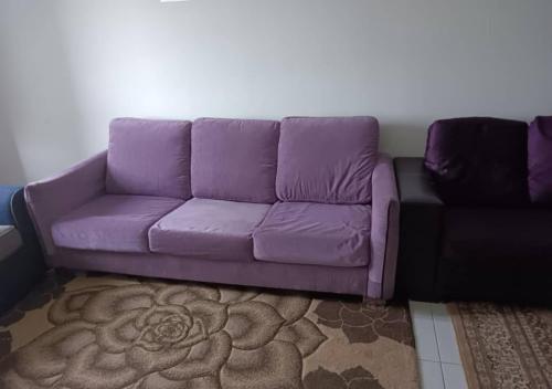 eine lila Couch im Wohnzimmer in der Unterkunft Homestay Danau Ria @ Gamuda Gardens in Pengkalan Kundang