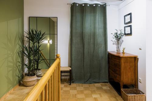 a hallway with a green shower curtain and a wooden staircase at Apartments Šolar in Bled