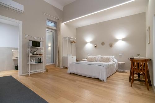 Un dormitorio blanco con una cama y una mesa. en Room24 L, en Bari