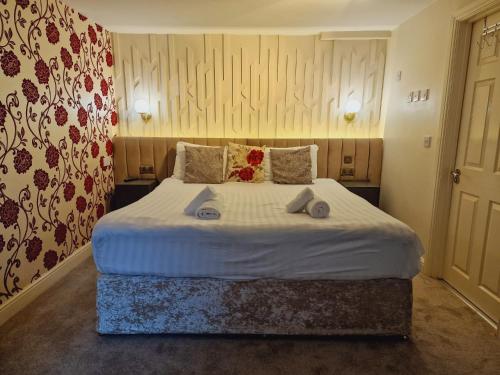 a bedroom with a large bed with towels on it at Wentworth House - Free Parking in Bath