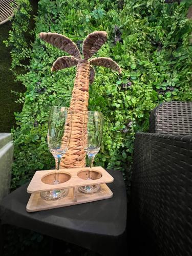 uma estátua de uma palmeira sobre uma mesa com copos de vinho em SPA de charme 6 pers avec Jacuzzi & Sauna privatifs au coeur de ville - Esprit Coco em Mulhouse