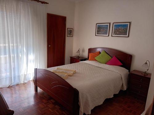ein Schlafzimmer mit einem großen Bett mit bunten Kissen in der Unterkunft familiahorta in Coimbra