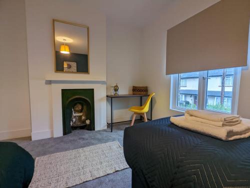 a bedroom with a bed with a fireplace and a mirror at 3 Bed 2 Lounge House up to 40pc off Monthly in Addlestone by Angel and Ken Serviced Accommodation Great Value for Long-term Stay in Addlestone