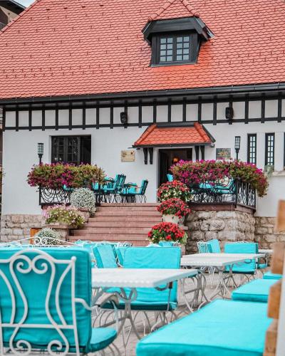 a group of chairs and tables in front of a building at Durmitor 41, kompleks Titova Vila in Palisad