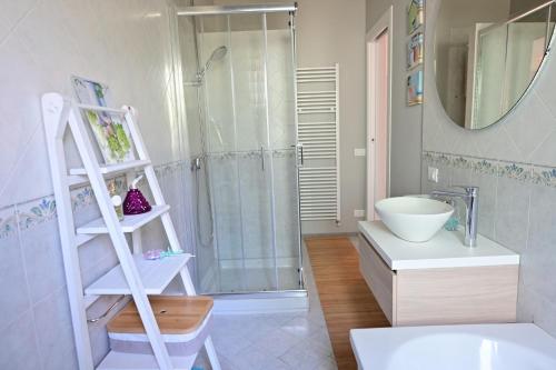a bathroom with a shower and a white shelf at Suite Dalmine in Dalmine