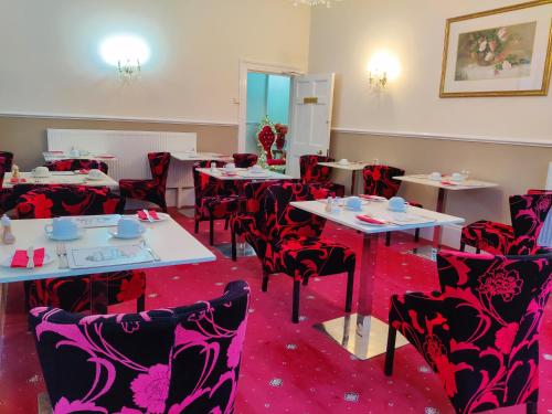 a dining room with tables and chairs and red carpet at Wentworth House - Free Parking in Bath