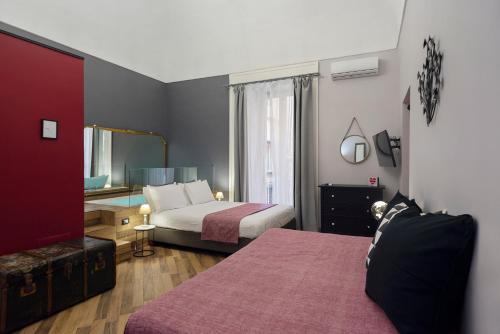 a hotel room with two beds and a mirror at Tredici Boutique Rooms in Naples