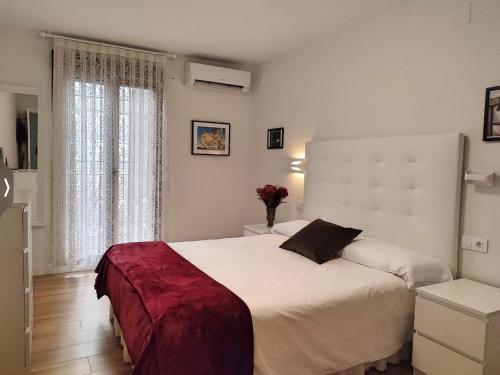 Un dormitorio con una gran cama blanca y una ventana en Aroma de azahar, en San Basilio en Córdoba