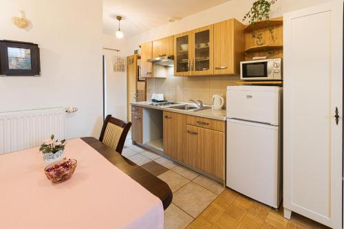 een keuken met een tafel en een witte koelkast bij Quercus Apartments Bled in Bled