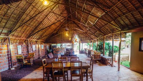 un restaurante con mesa de madera y sillas en Kilimanjaro Scenic Lodge, en Moshi