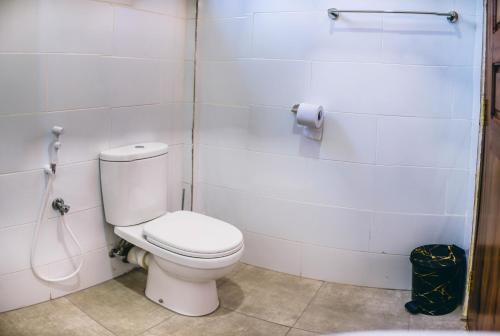 a bathroom with a white toilet and a hose at Kilimanjaro Scenic Homestay in Moshi