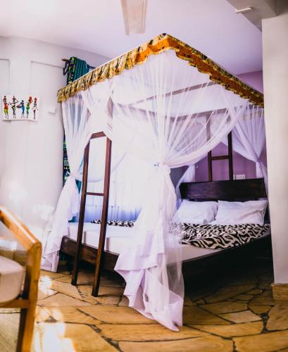 a bedroom with a canopy bed with white curtains at Kilimanjaro Scenic Homestay in Moshi