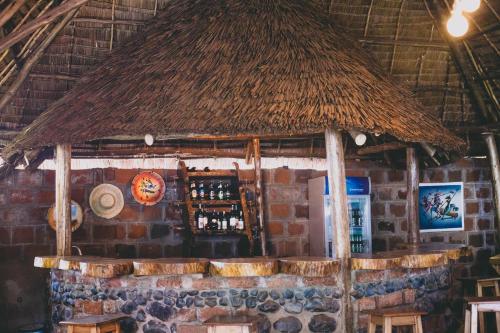 a bar with a straw roof in a restaurant at Kilimanjaro Scenic Homestay in Moshi