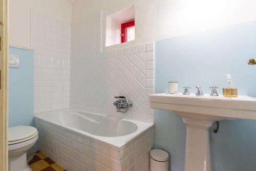 a bathroom with a tub and a sink and a toilet at Casa Palmira - La Casina in Polcanto