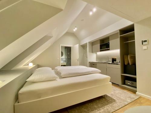 a bedroom with a white bed and a kitchen at Blackhome Wien I contactless check-in in Vienna