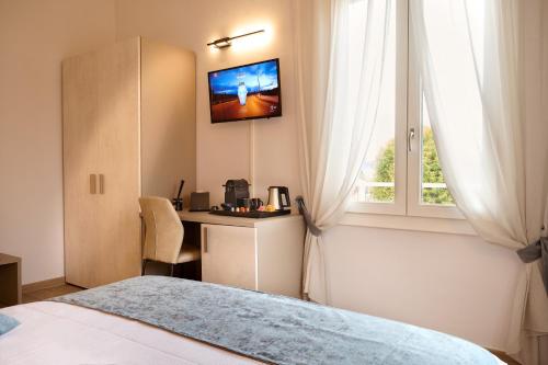 a bedroom with a bed and a desk and a window at D'AZEGLIO 62 LUXURY ROOMS in Bologna