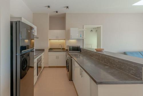 una cucina con armadi bianchi e piano di lavoro di New 2-Bedroom, Top Location-Cyan, El Gouna a Hurghada