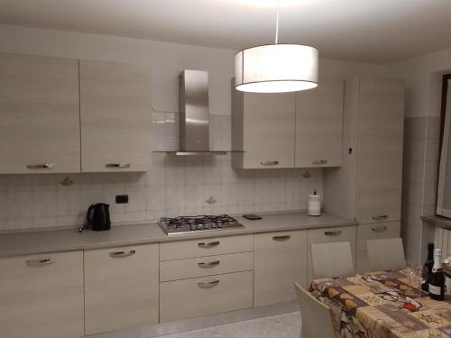 a kitchen with white cabinets and a stove top oven at Casa Lory in Colico