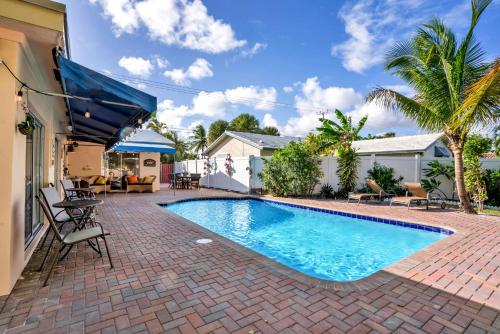 a swimming pool in a yard with a brick patio at 4 bd Near beach spacious solar heated pool waterfront home in Pompano Beach