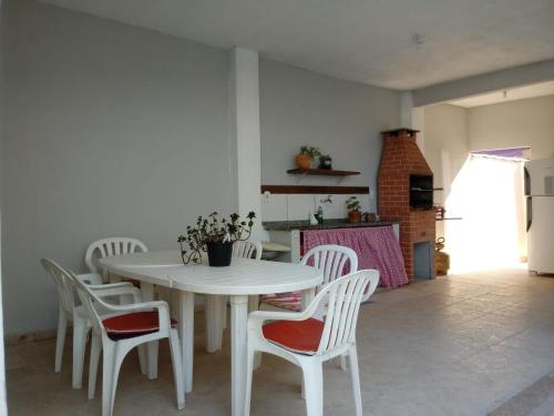 una mesa blanca y sillas en una habitación en Aluguel Temporada CABO FRIO, en Cabo Frío