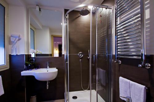 ローマにあるホテル グラヴィーナ サン ピエトロのバスルーム(ガラス張りのシャワー、シンク付)