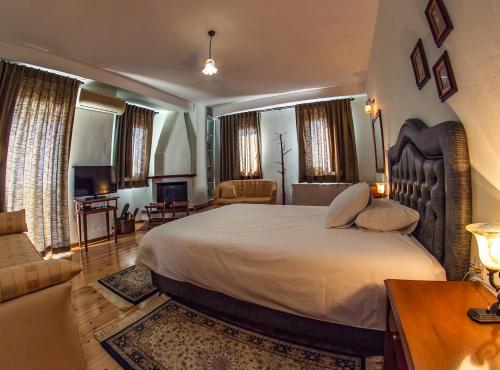a bedroom with a large bed and a living room at Horizon Hotel in Ioannina