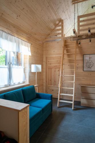 a living room with a blue couch and a ladder at Poncyljuszówka in Szczyrk