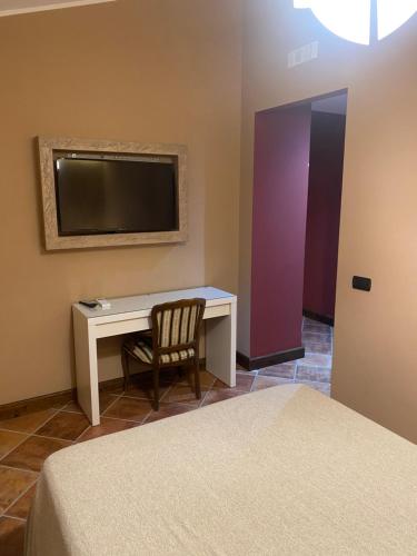 een slaapkamer met een bureau, een tv en een stoel bij Colle De Siena Rooms in Cassino