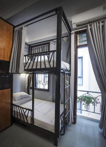 two bunk beds in a room with a window at Nusmile's Hostel and Travel in Hanoi