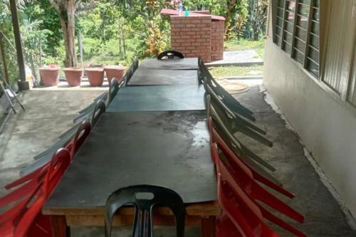 a long table with chairs sitting around it at Teratak An Nur: A village on top of the hill in Kuala Pilah