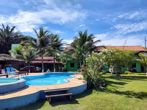 un complejo con piscina y palmeras en Sol da Onda Pousada e Flats, en Barra Grande