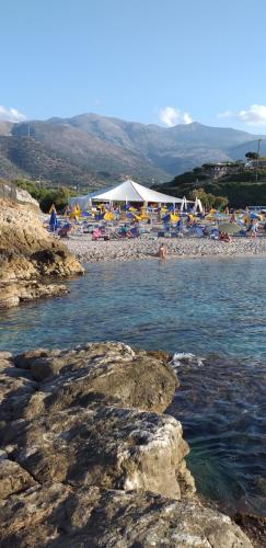 a beach with a bunch of umbrellas and chairs at Petrino in Sisi with private pool and garden in Sissi