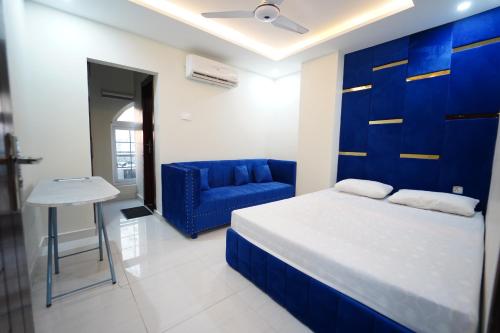 a bedroom with a blue bed and a blue chair at Premier Heights Jhelum in Jhelum