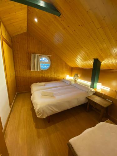 Un dormitorio con dos camas en una cabaña de madera. en Duplex 3 dormitorios en plaza de Andalucía, en Sierra Nevada