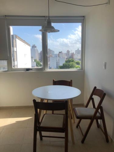 mesa y sillas en una habitación con ventana en Coqueto departamento boutique en Mar del Plata