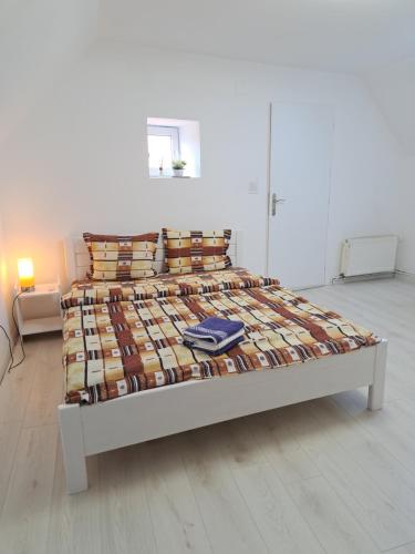 uma cama num quarto branco com uma cama grande em Casa Merisor em Sibiu